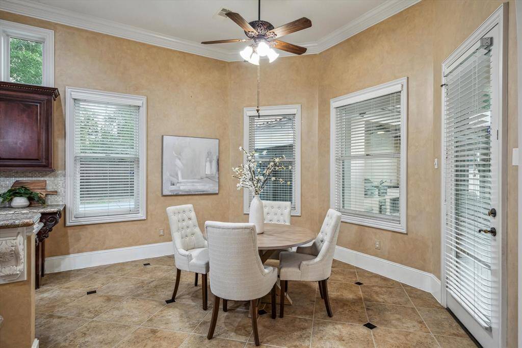 Surrounded by windows and bathed in natural light, this elegant breakfast nook is the perfect spot to start your day in style.