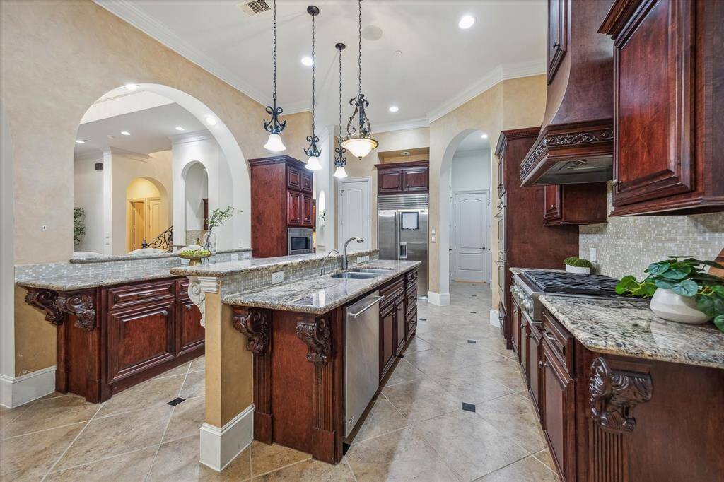 A true chef’s haven—rich custom cabinetry, intricate millwork, and a grand dual-height island with seating make this kitchen as functional as it is beautiful.