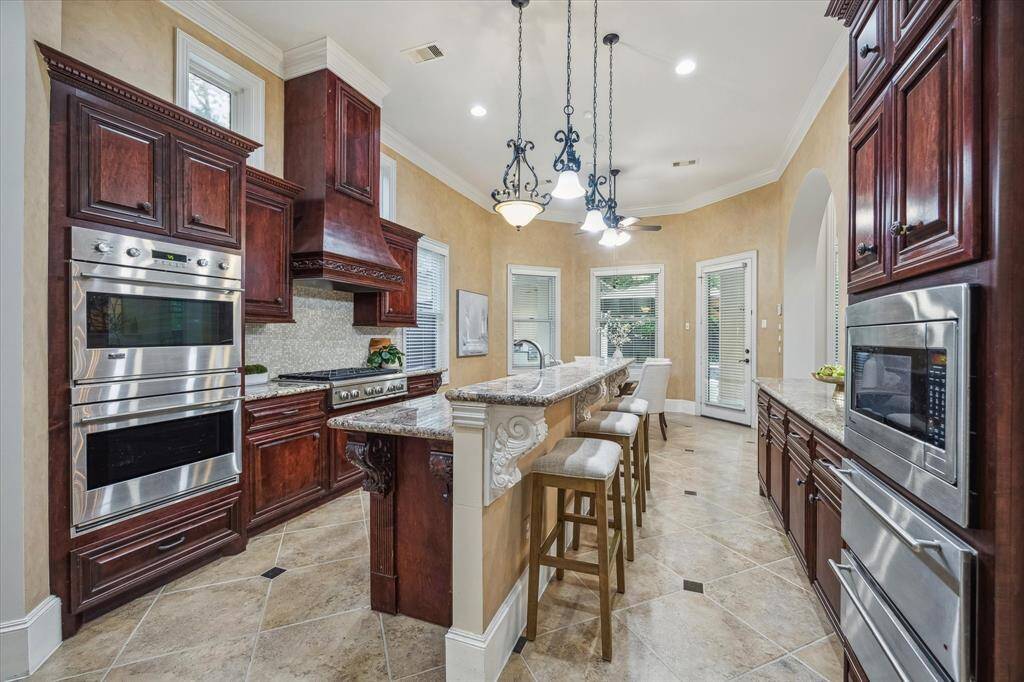 Showcasing top-tier stainless appliances, double ovens, and a statement range hood, this exquisite kitchen is designed to impress.