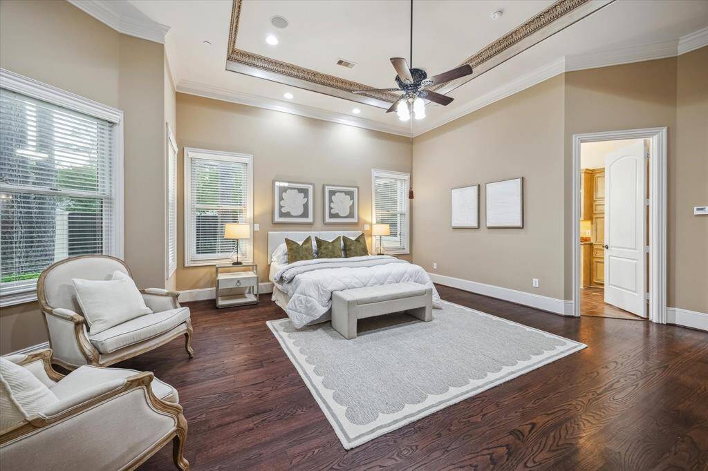This spacious primary suite showcases stunning trim detail, a deep tray ceiling, and seamless flow into the opulent ensuite bath.
