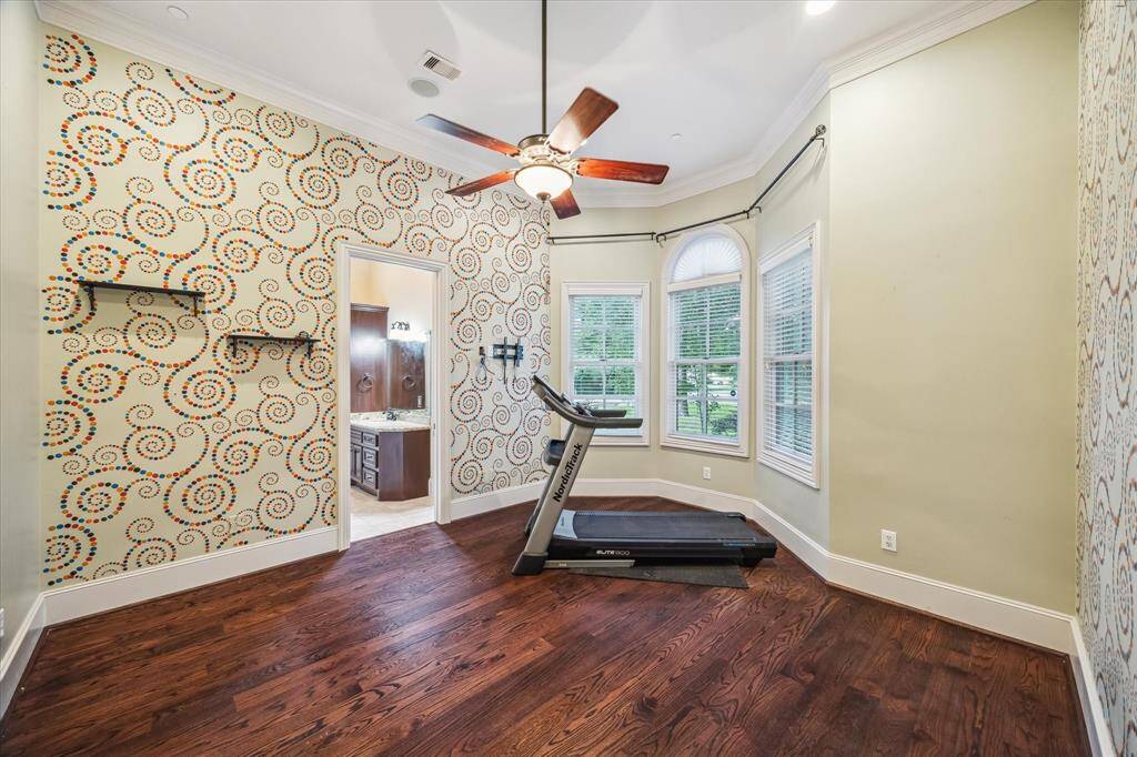 Located just off the primary suite, this second bedroom on the first floor offers flexibility for guests, multi-generational living, or a private home gym—with charming bay windows and an en-suite bath for added comfort.