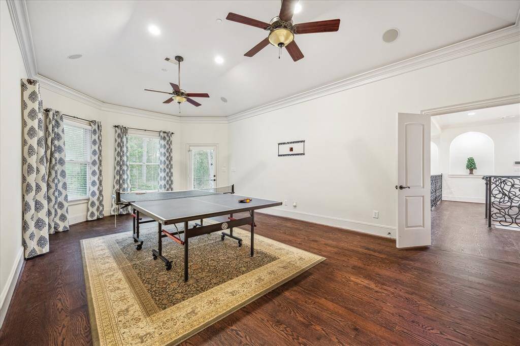 Expansive windows, dual ceiling fans, and patio access elevate this bright and airy game room into the ultimate flex space for play or relaxation.