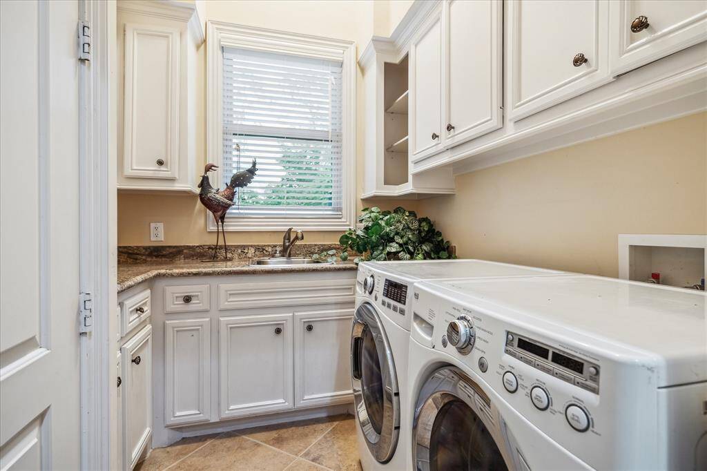 The first floor laundry room is as functional as it is stylish, with granite counters, abundant cabinetry, and a deep sink for utility and ease.