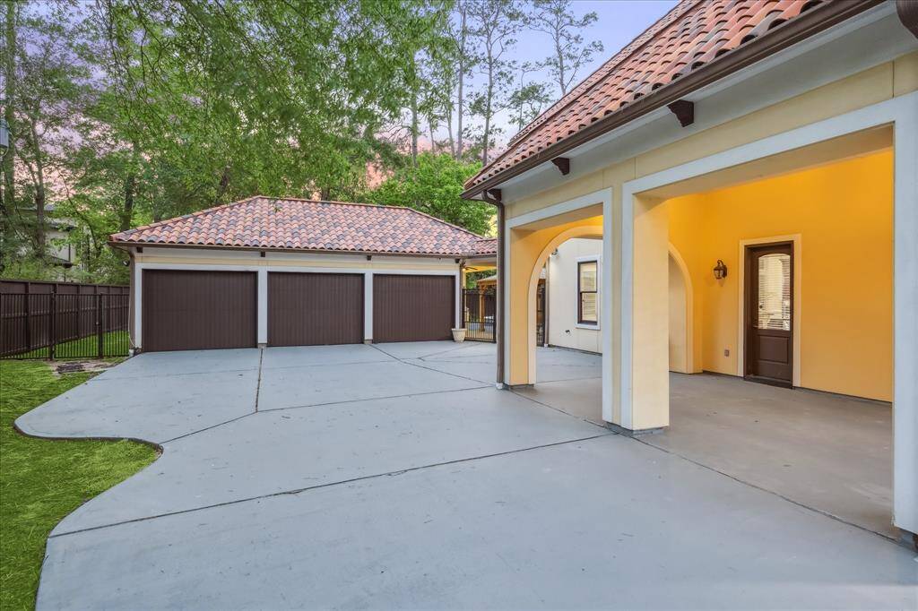 Gated motor court leads to the 3-car detached garage and covered walkway—blending convenience with architectural charm.