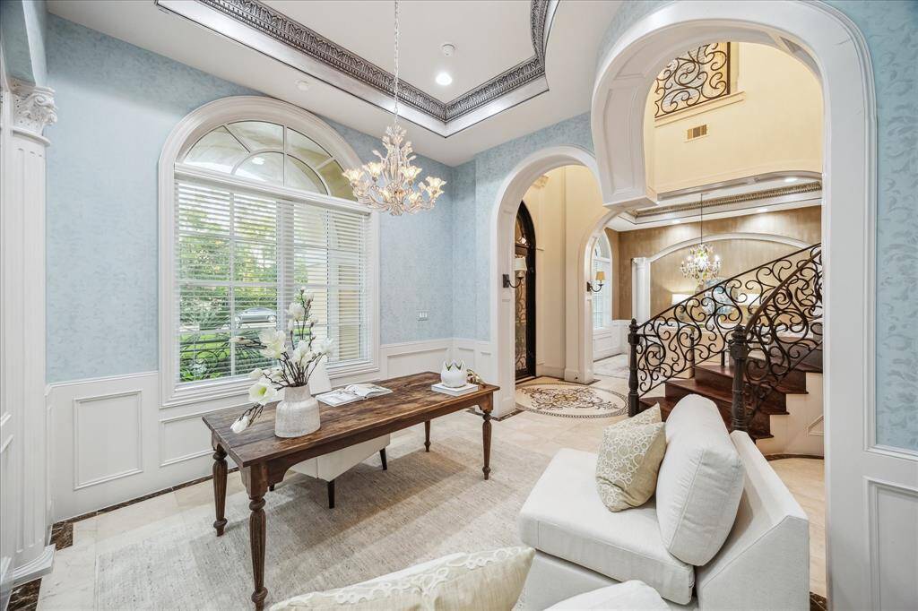 Off the foyer, this refined space is perfect for a study or music room, framed by arched openings and custom trimwork.