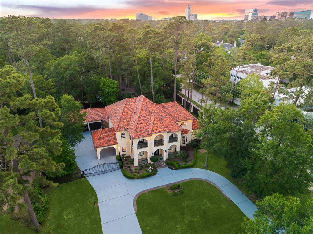 A breathtaking first impression—this Mediterranean-style estate stuns with a grand circular drive, private gate, and lush wooded surroundings, all just minutes from the heart of Memorial.