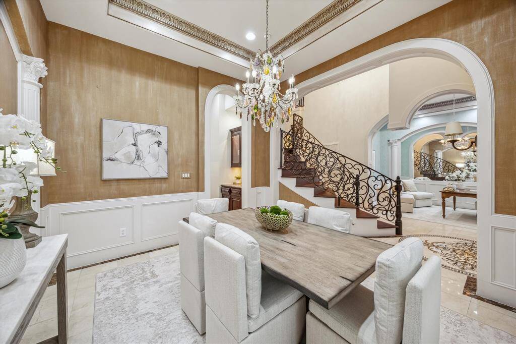 Arched windows and richly detailed molding elevate this dining space with natural light and architectural character.