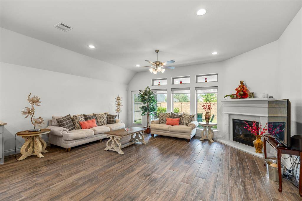 Spacious living room with ceramic tile flooring and a cast stone fire place. How beautiful!