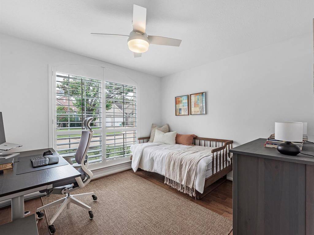 1 of 2 Secondary Bedrooms with Plantation Shutters with front yard views.