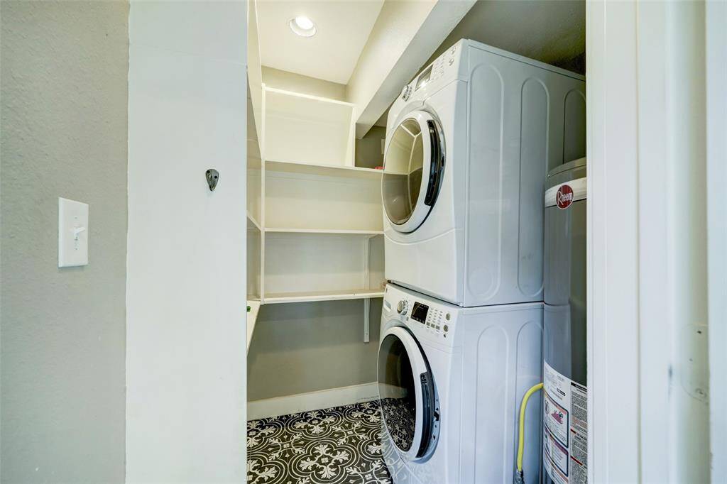 Oversized laundry room with stackable washer and dryer that convey in addition to ample pantry space.