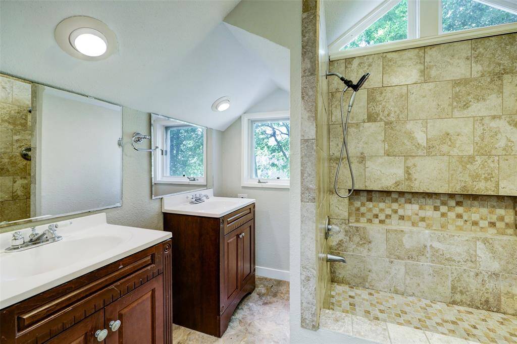 Dual vanities are present in the primary bath, complete with abundant natural sunlight.