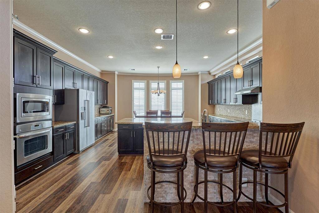 The kitchen features timeless finishes and includes a breakfast bar for additional seating.