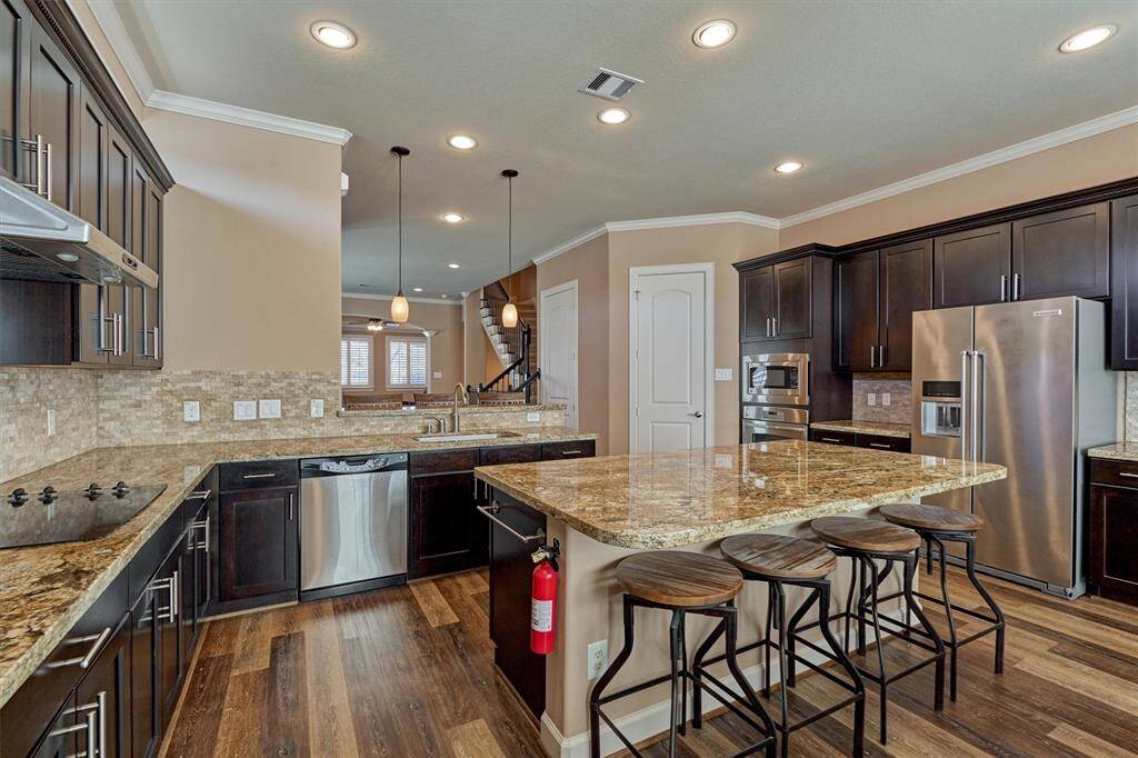 Additional seating is available at the island and a walk in pantry is located to the right in this photo.