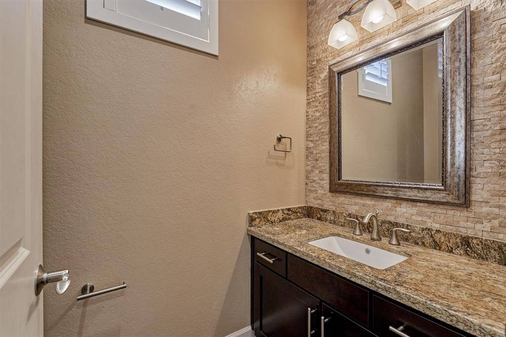 A powder room with a striking accent wall of stacked stone is conveniently located on the second floor.