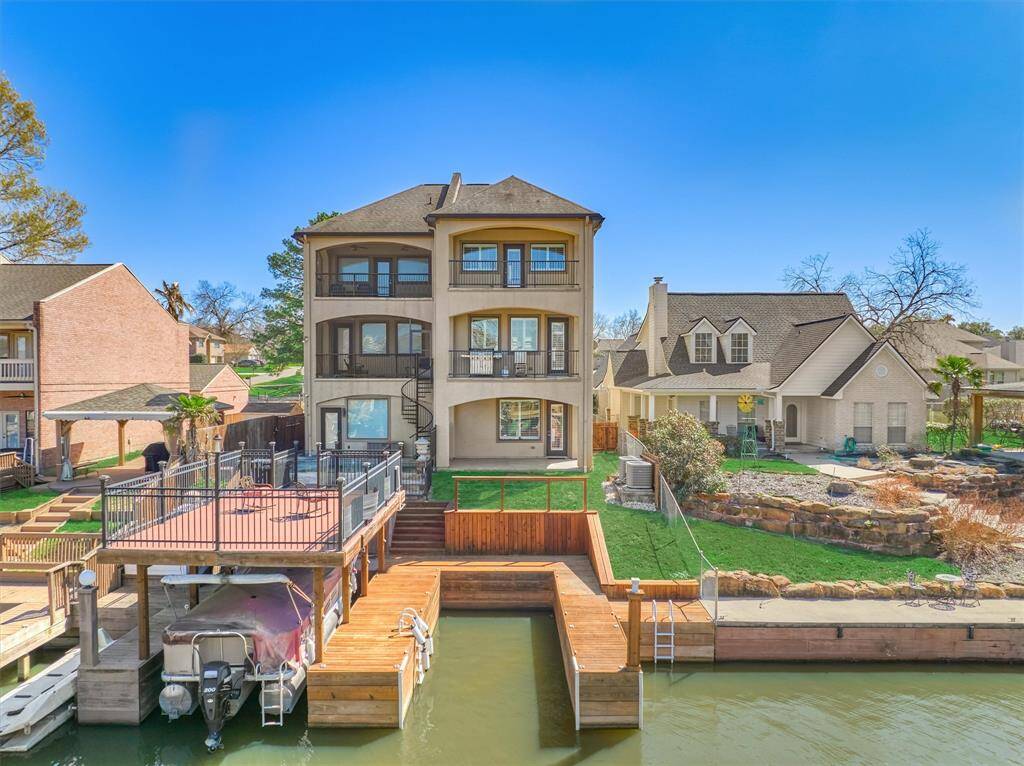 A view of the back of the home with boat slip and three outdoor porches/balconies for outdoor living.