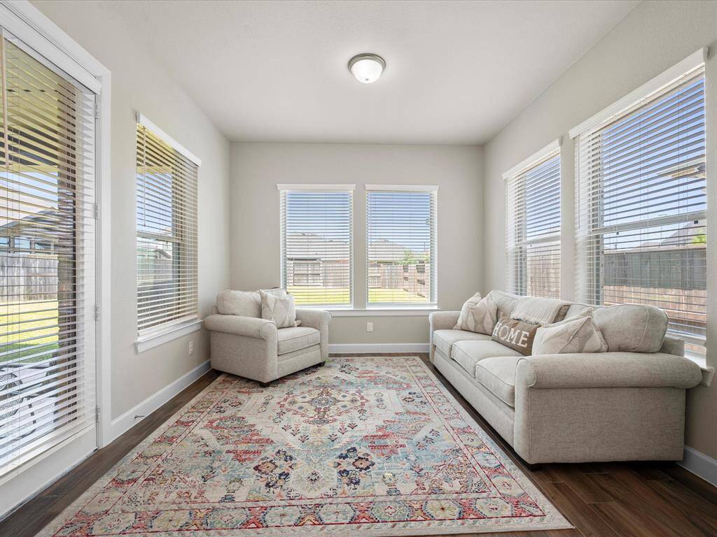 Bright and flexible den/flex space with expansive windows framing views of the backyard. This room offers endless possibilities, whether as an additional sitting area, home office, or game room—tailor it to your needs.