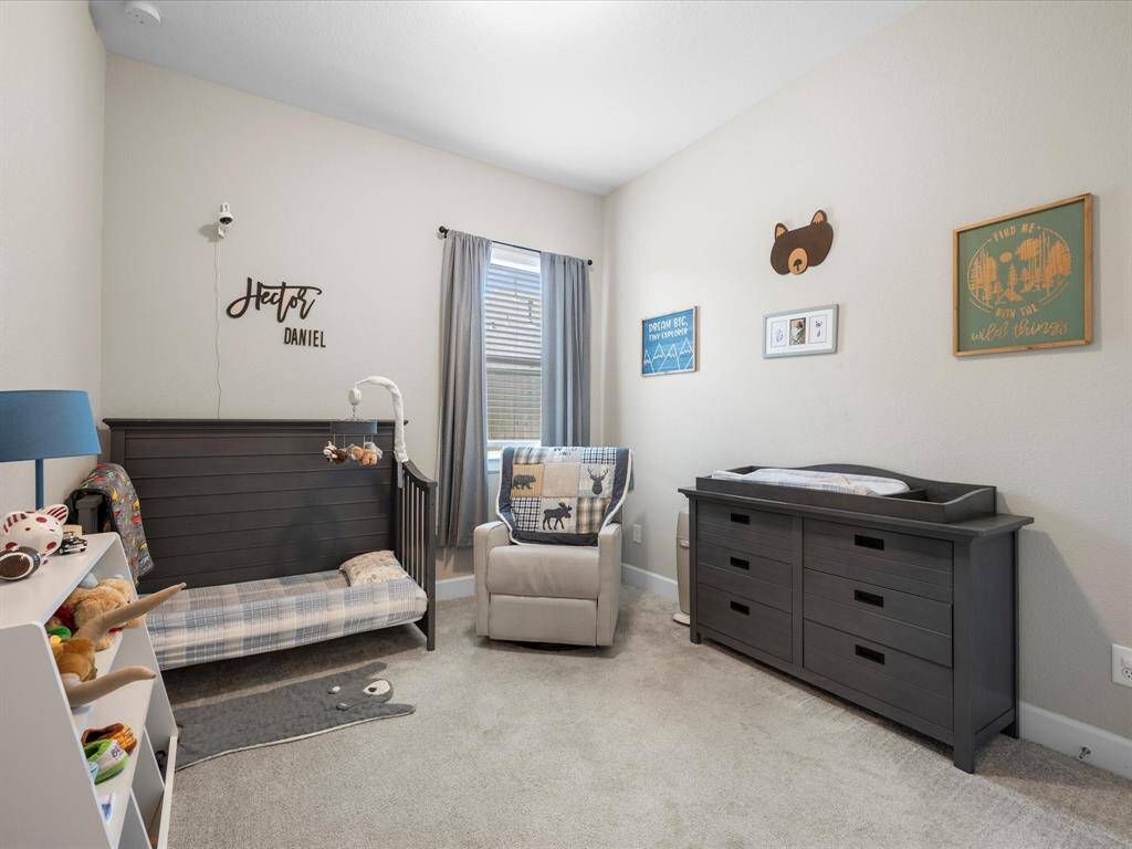 Versatile secondary bedroom filled with natural light, featuring soft carpeted flooring and neutral tones. Perfectly suited for use as a guest room, nursery, additional home office, or playroom—tailor the space to fit your needs.