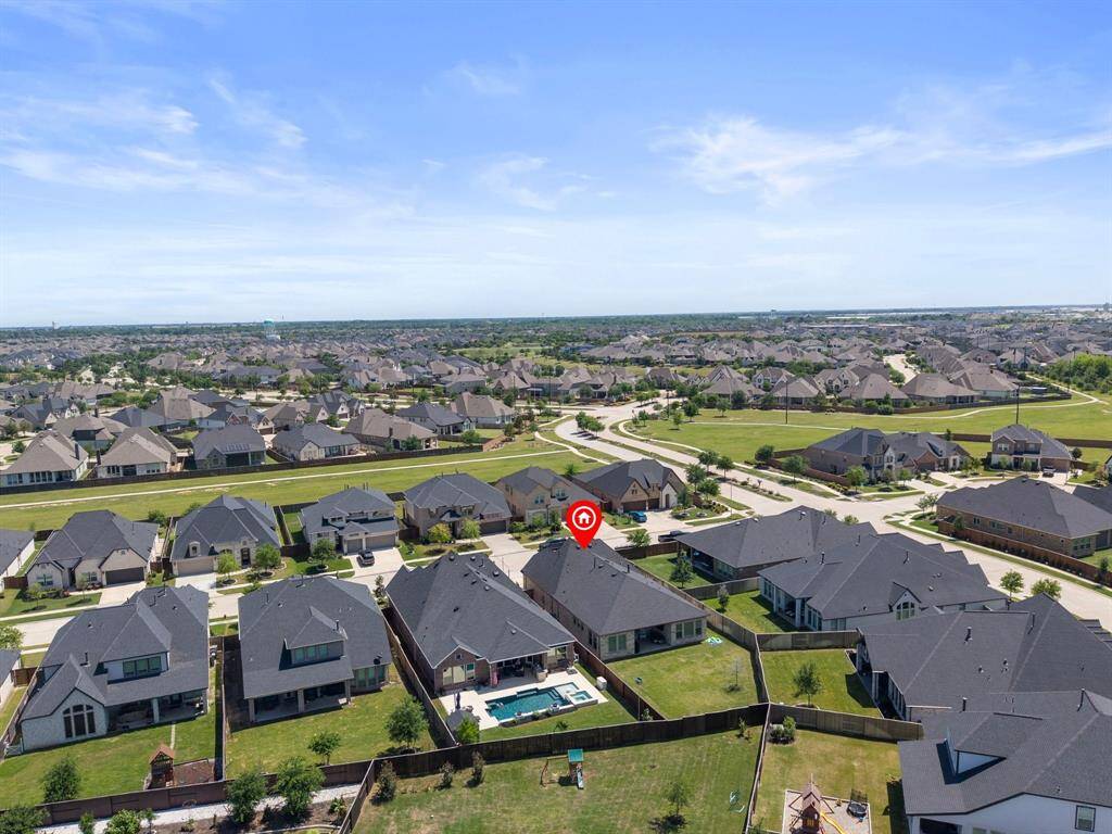 The expansive lot offers a clear perspective of the property’s layout, showcasing both the house and its generous outdoor spaces.