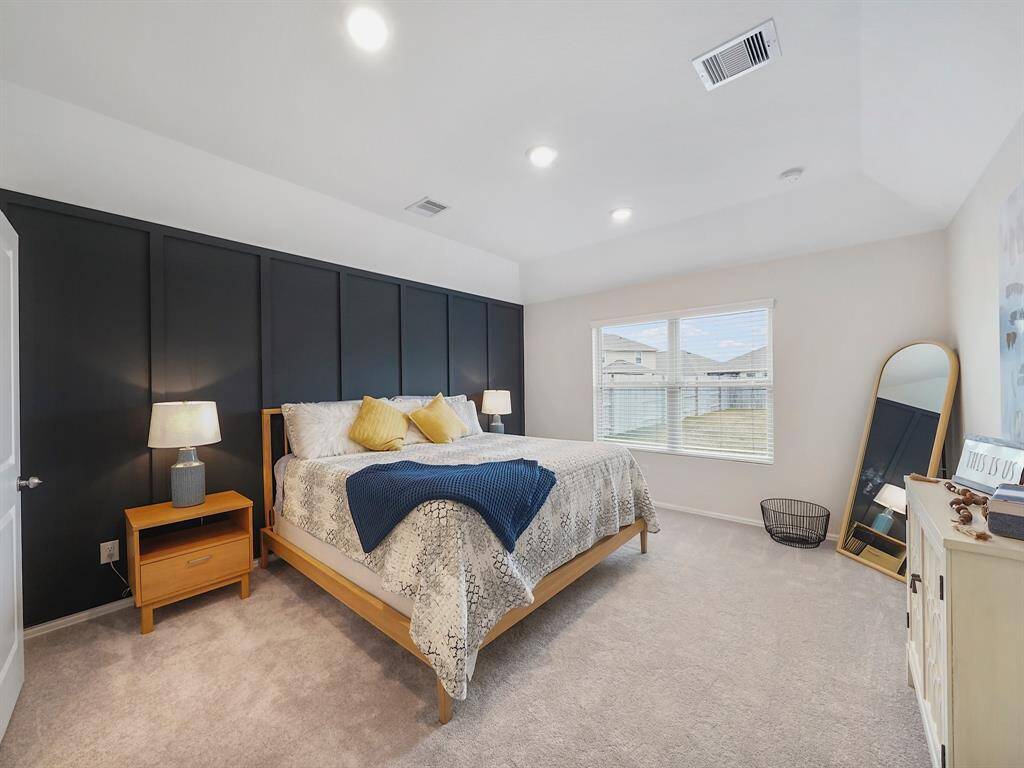 Discover your dream retreat in this spacious primary suite, featuring a stunning accent wall that adds a touch of elegance. Enjoy the airy feel provided by the vaulted ceiling, complemented by an ensuite bathroom for your convenience and privacy.