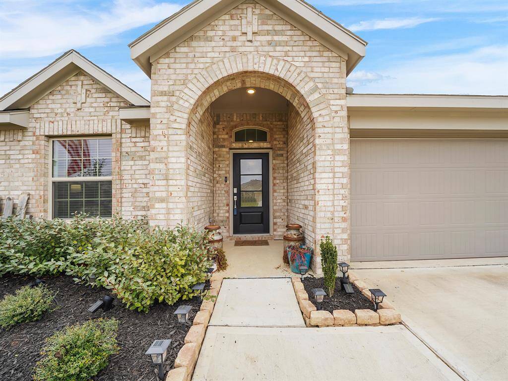 Experience elegance in this stunning property featuring gorgeous landscaping and a captivating covered arched entryway. Perfectly designed for charm and curb appeal, it invites you into a serene oasis.