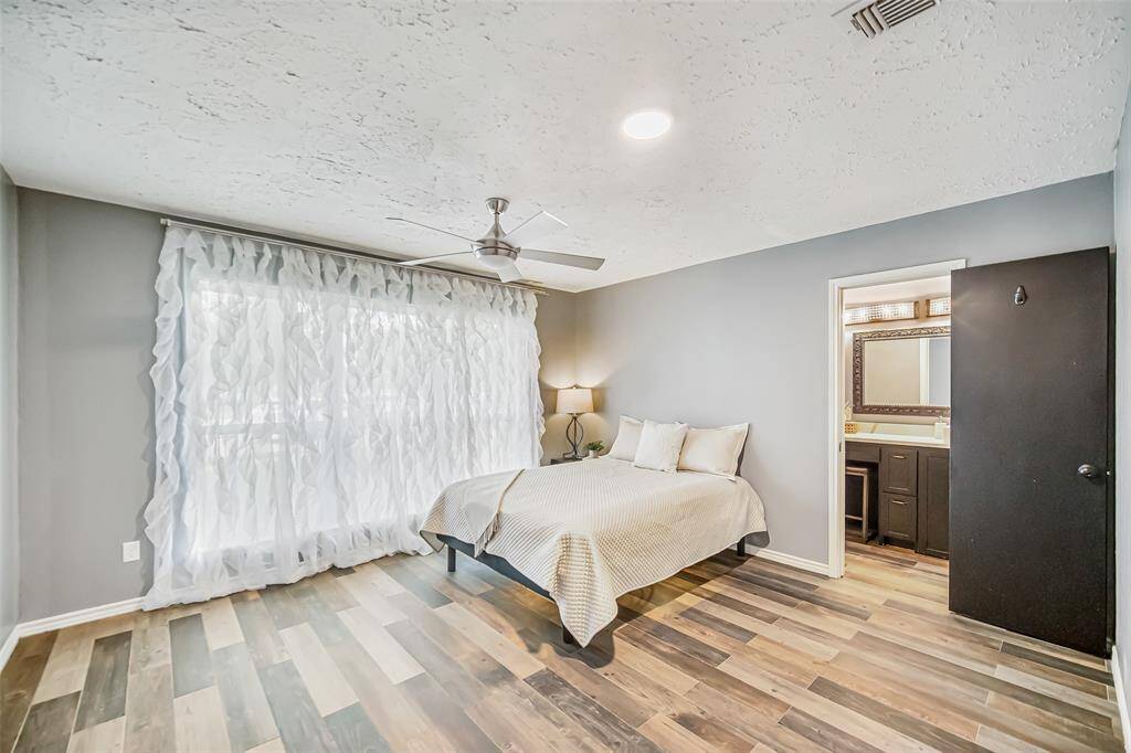 Step into the primary bedroom and say "Wow!" The rich floors, the neutral paint, the beautiful window, and striking black door all combine to make this a true, welcoming retreat.