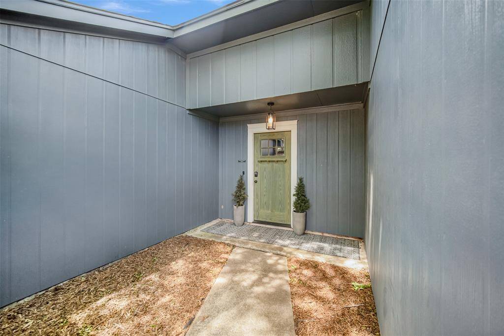 This welcoming courtyard and updated mission-style front door combine to make this a shaded and inviting entryway to the home.
