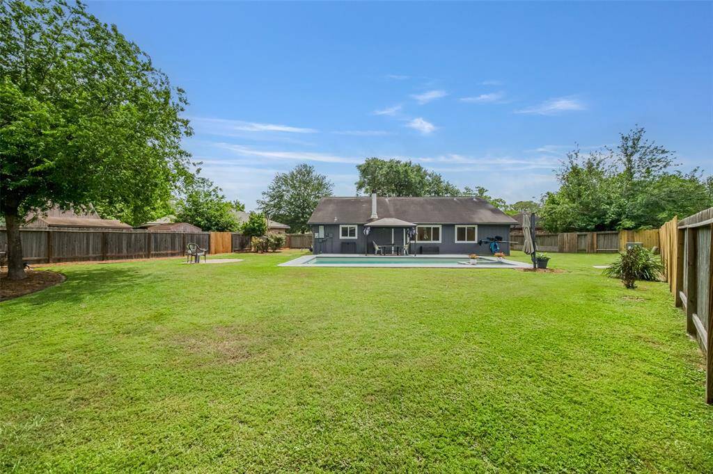The backyard has lovely landscaping, but it can also be a blank slate for gardening, a play fort, a trampoline, or all three!
