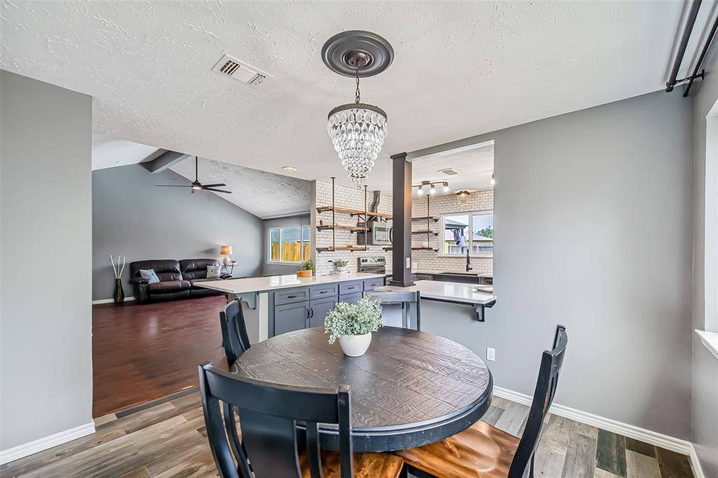 From this angle, you can see the dining area is adjacent to the kitchen and family room, and it features a beautiful light fixture.