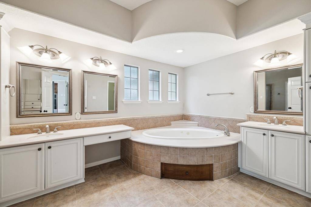 Unwind in the spacious jetted tub, framed by elegant symmetrical tilework and three textured artscape windows that provide privacy and natural light.