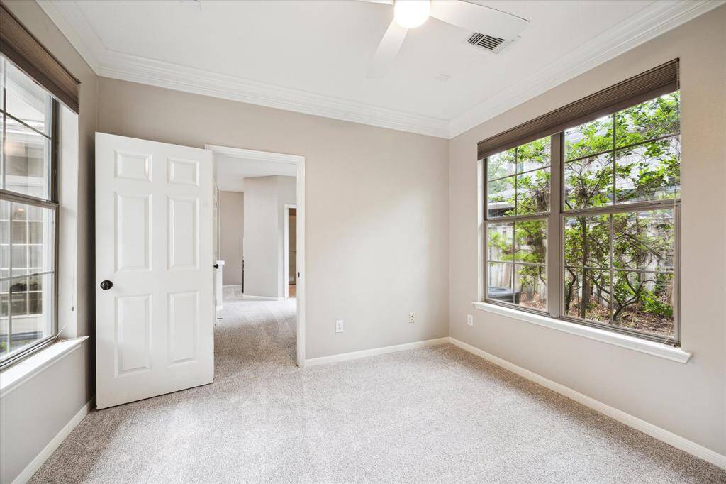 Oversized windows frame tranquil views of the gated courtyard while filling the space with natural light.