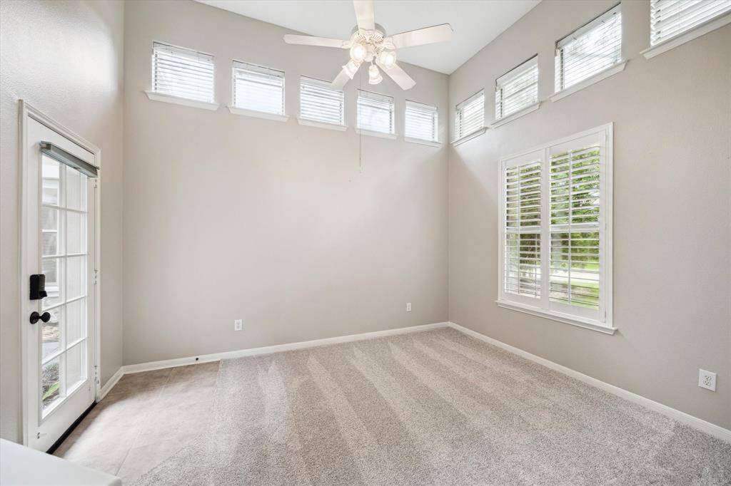 This stunning guest suite features a windowed door that opens to the gated courtyard, along with a large window offering views of the beautifully landscaped front yard. Soaring ceilings and a series of thoughtfully placed windows fill the room with natural light and add to its distinctive charm.