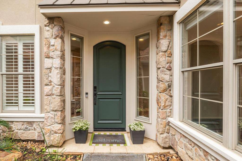 A charming rich green front door serves as a welcoming focal point, flanked by two elegant sidelights that bring in natural light and enhances the home's inviting appeal.