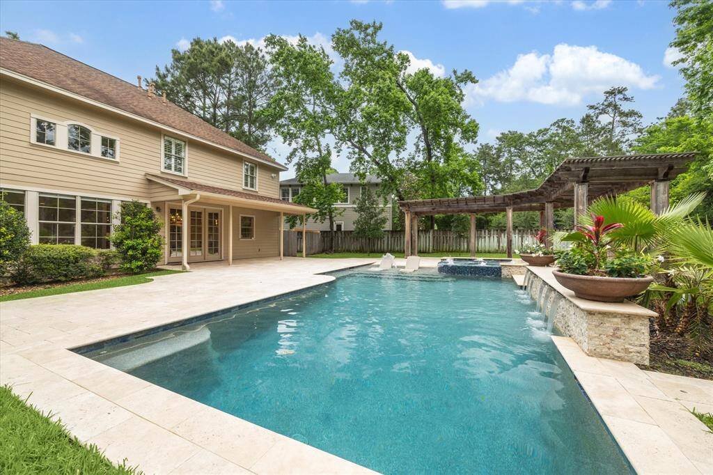 Take in this stunning rear elevation, showcasing the beautiful pool and spa, complemented by a long covered pergola. The perfect combination of relaxation and entertainment, this space is wonderful!