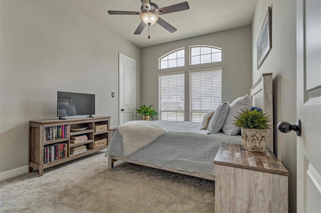 Secondary bedroom with ceiling fan and walk-in closet.