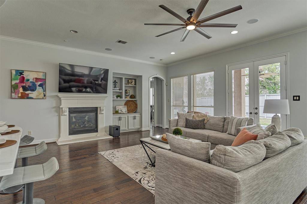 Stone gas log fireplace is the center of the living room.  Built-in cabinetry offers space for decor.