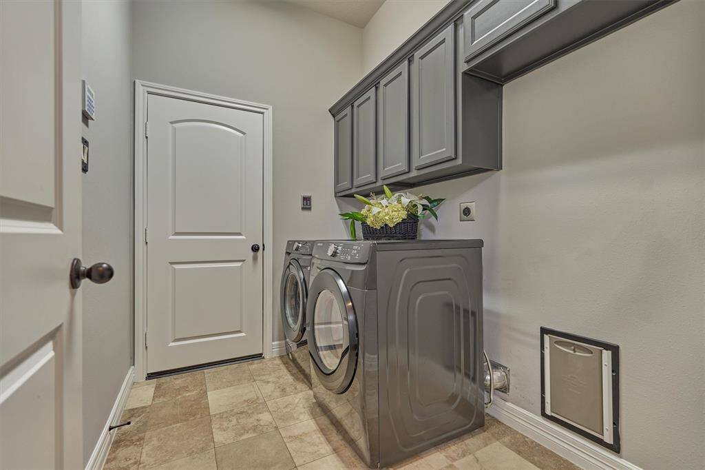 Laundry room is off the garage and has ample cabinet storage and room for second refigerator.