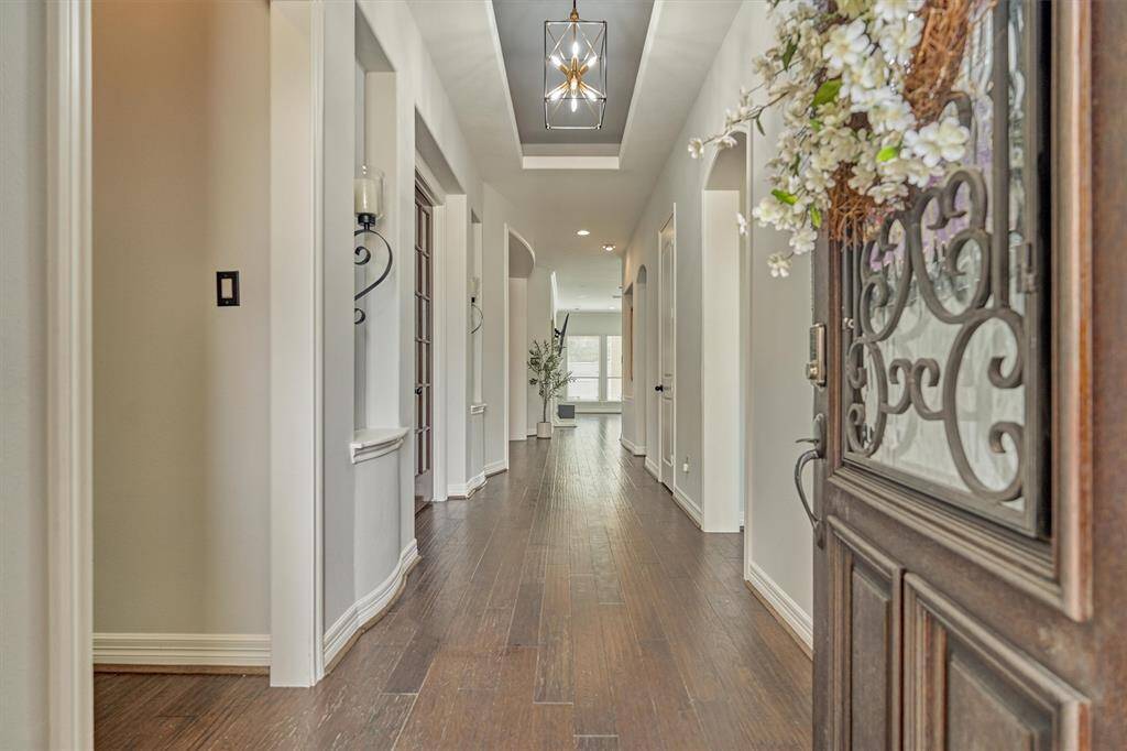 The welcoming foyer with warm hardwoods and custom lighting.  Whole home was painted in 2022.