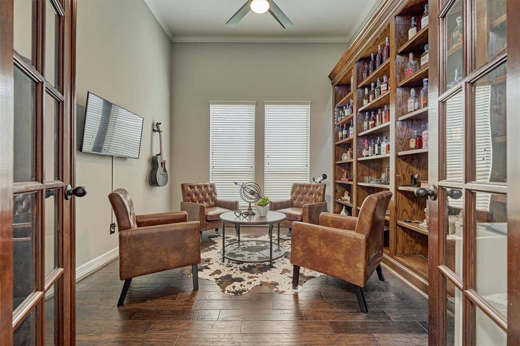 Double French doors lead to the study that is currently being used as a boubon sitting room.  This room has beautiful built in cabinets and ceiling fan.