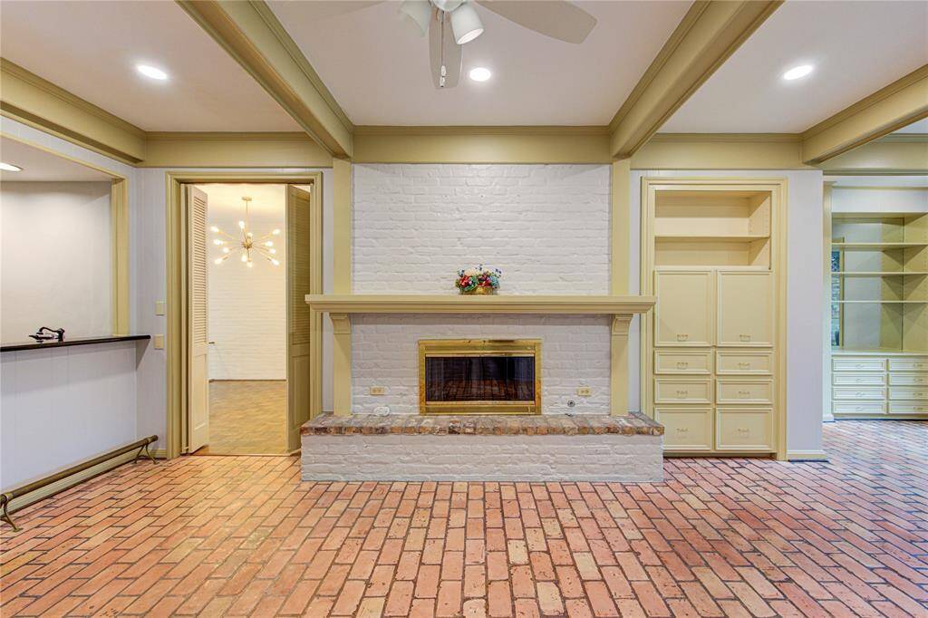 The family room features a gas-log fireplace, built ins, and brick flooring.