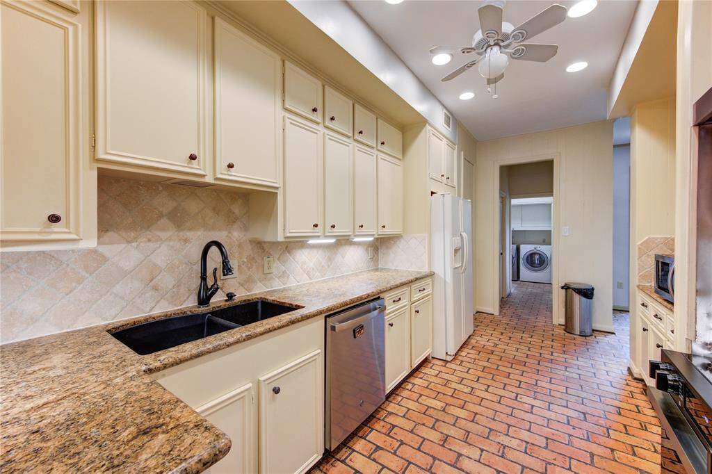 Under-mount sink, plenty of cabinets for storage, and a stainless steel dishwasher.
