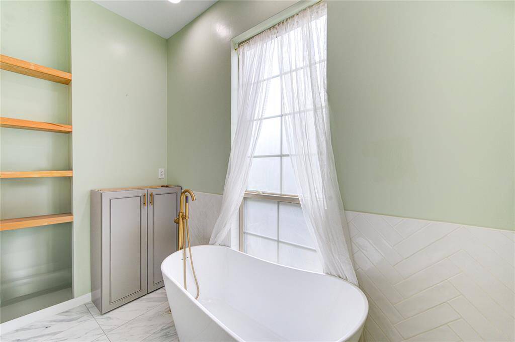 Elegant freestanding tub with additional storage space on left.