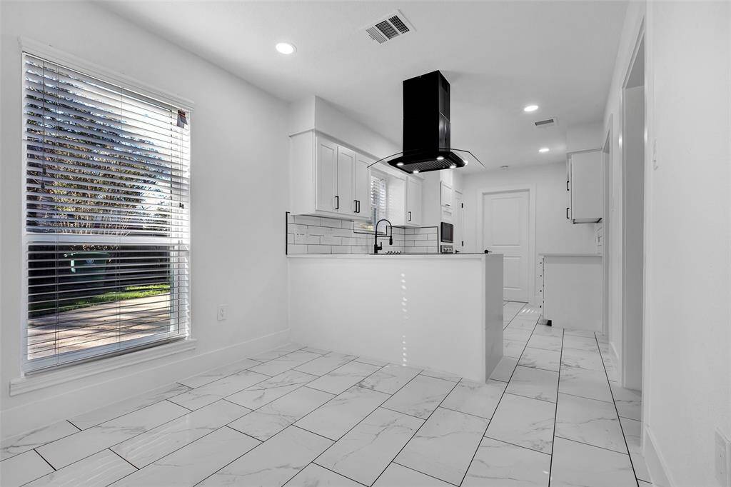 This view from the potential breakfast area showcases the kitchen.