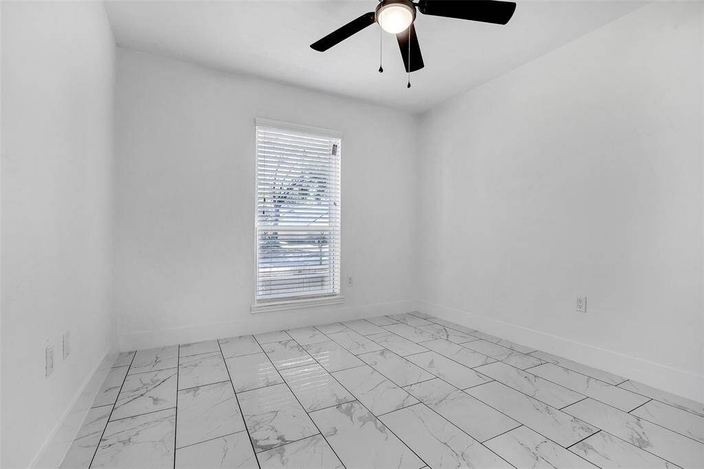 The bedroom features a tiled floor, ceiling fan, and a window for natural light. With its versatile layout, this space is ready for you to customize to your personal style.