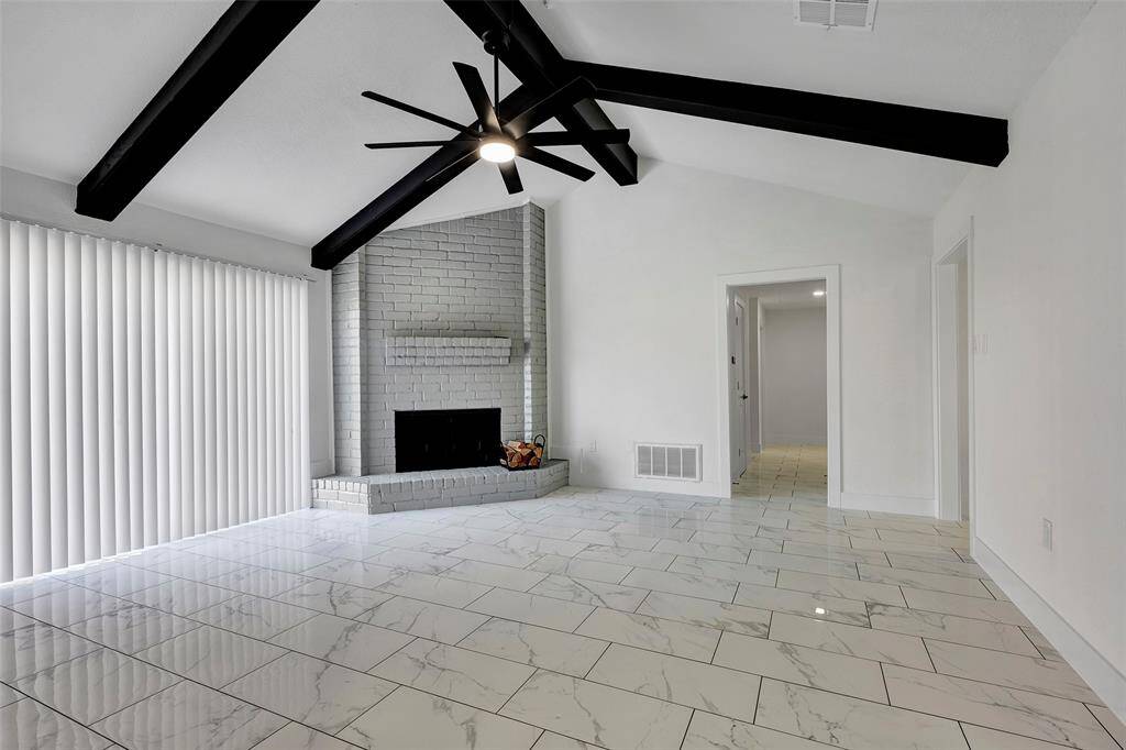 It features a charming wood-burning brick fireplace and a stylish tiled floor, creating a warm and inviting atmosphere.