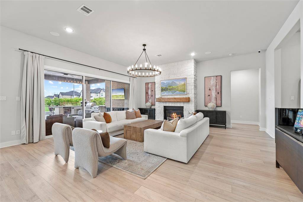 A chic living room space flooded with natural light is delightful! The wall of windows not only brings in abundant sunlight but also offers expansive views of the surrounding landscape, connecting the indoors with the outdoors in a seamless way.