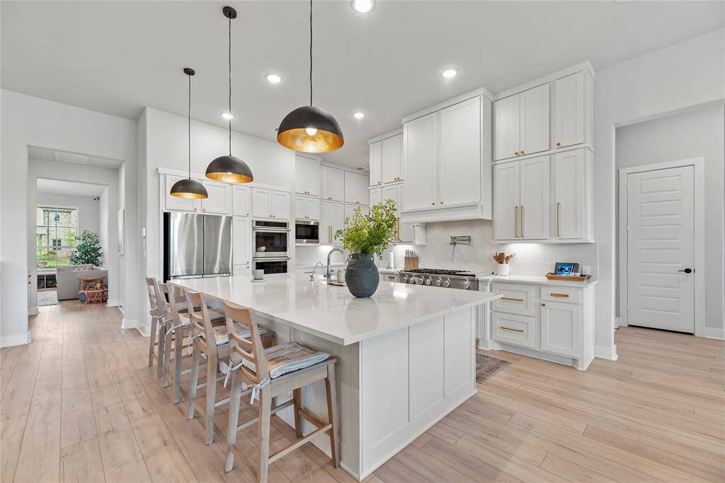 The sprawling island with breakfast bar seating serves as a versatile centerpiece, providing additional workspace, storage, and seating for casual dining or entertaining.
