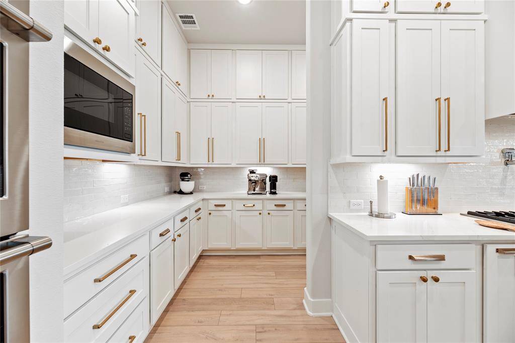 Crisp white cabinets with updated hardware provide a clean and timeless look, enhancing the sense of brightness and openness in the space.