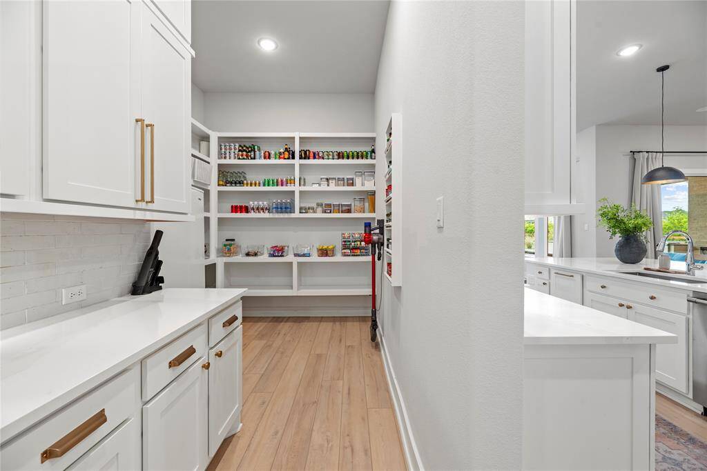 The huge walk-in pantry features granite counters and coordinating cabinets, to keep your kitchen counters clear.