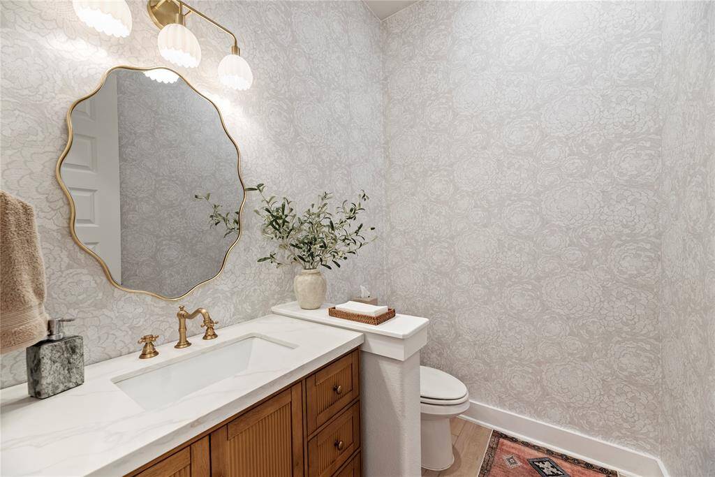 A beautifully updated half bath, now featuring fresh, modern wallpaper that adds a touch of elegance and style.