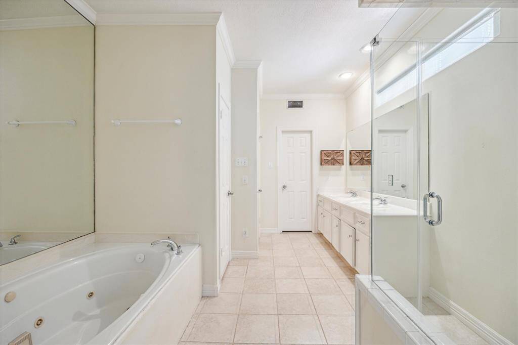 Elegant primary bathroom featuring a luxurious walk-in shower and a deep soaking tub, creating a spa-like retreat.
